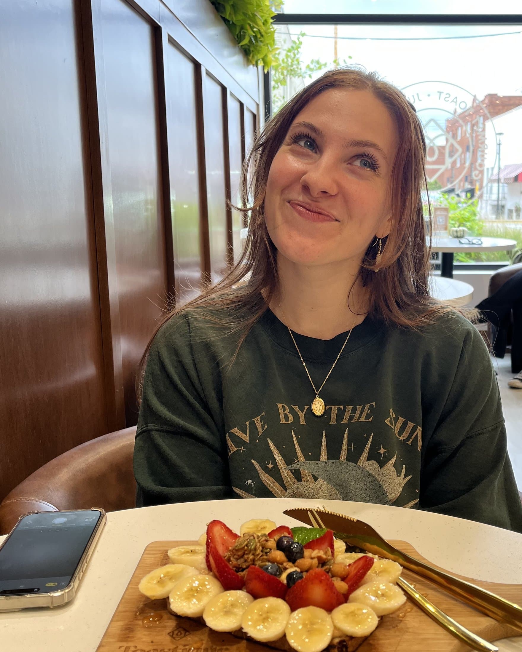 Jea at a café, smiling over breakfast